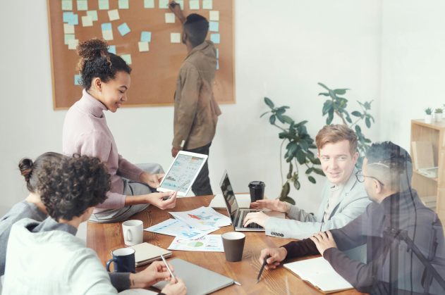 A diverse group of professionals discussing ideas in a modern office setting. Perfect for business and teamwork concepts.